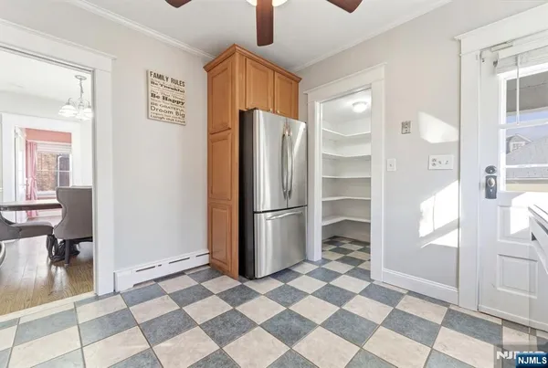 a view of a refrigerator in kitchen and an empty room