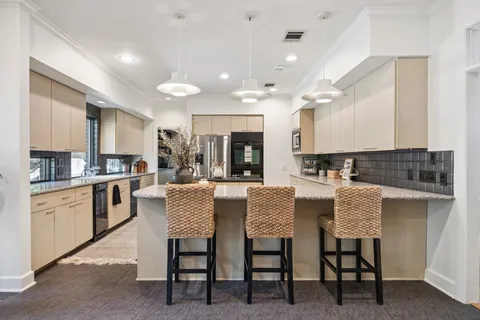 a kitchen with stainless steel appliances granite countertop a refrigerator a stove and a sink