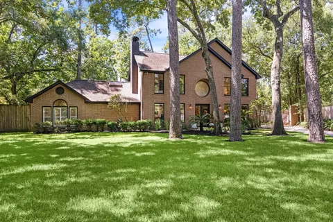 a view of a house with a big yard and large tree
