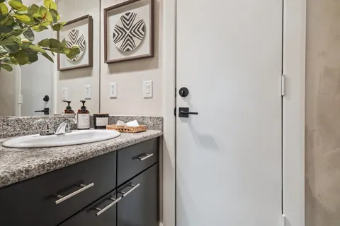 a bathroom with a granite countertop sink and a mirror