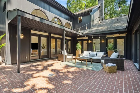 a backyard of a house with chairs and a tree