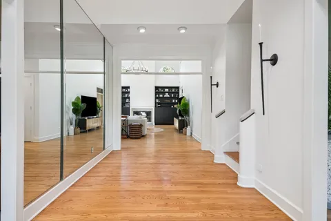 a hallway view with wooden floor and windows