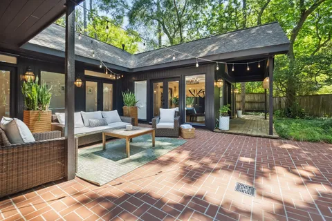 a view of a chair and table in backyard of the house