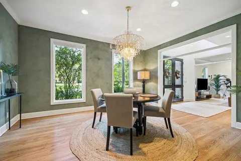 a dining room with furniture a chandelier and wooden floor