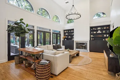 a living room with furniture a chandelier and a dining table