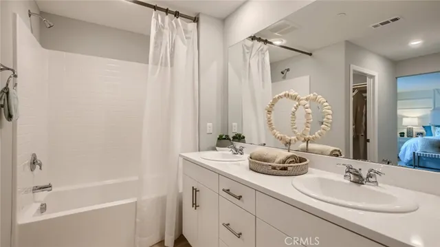 a bathroom with a double vanity sink tub and shower