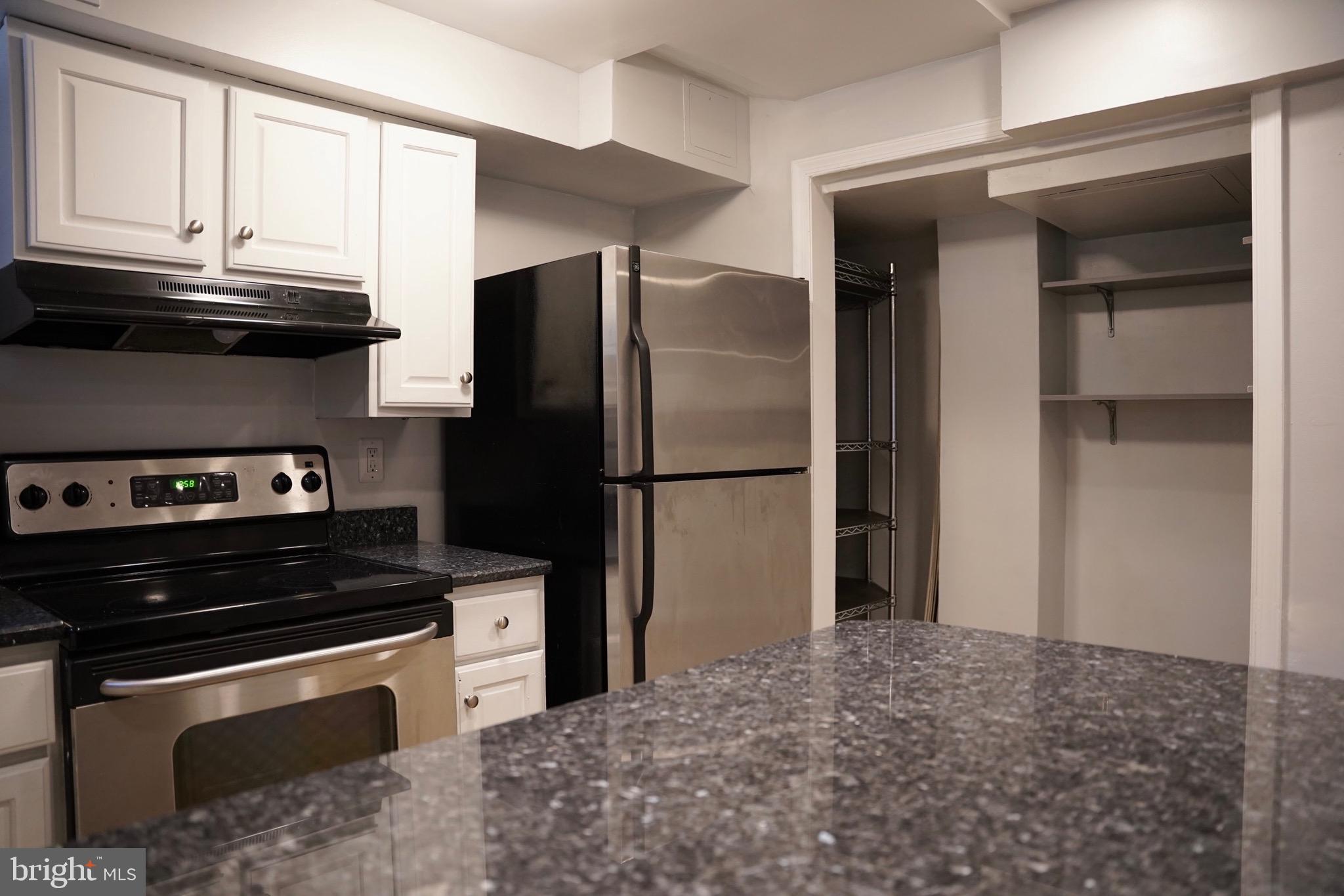 1321 Fairmont Street Northwest, Unit 3 Washington, DC 20009 - Photo 4 of 13 a kitchen with a refrigerator stove and cabinets