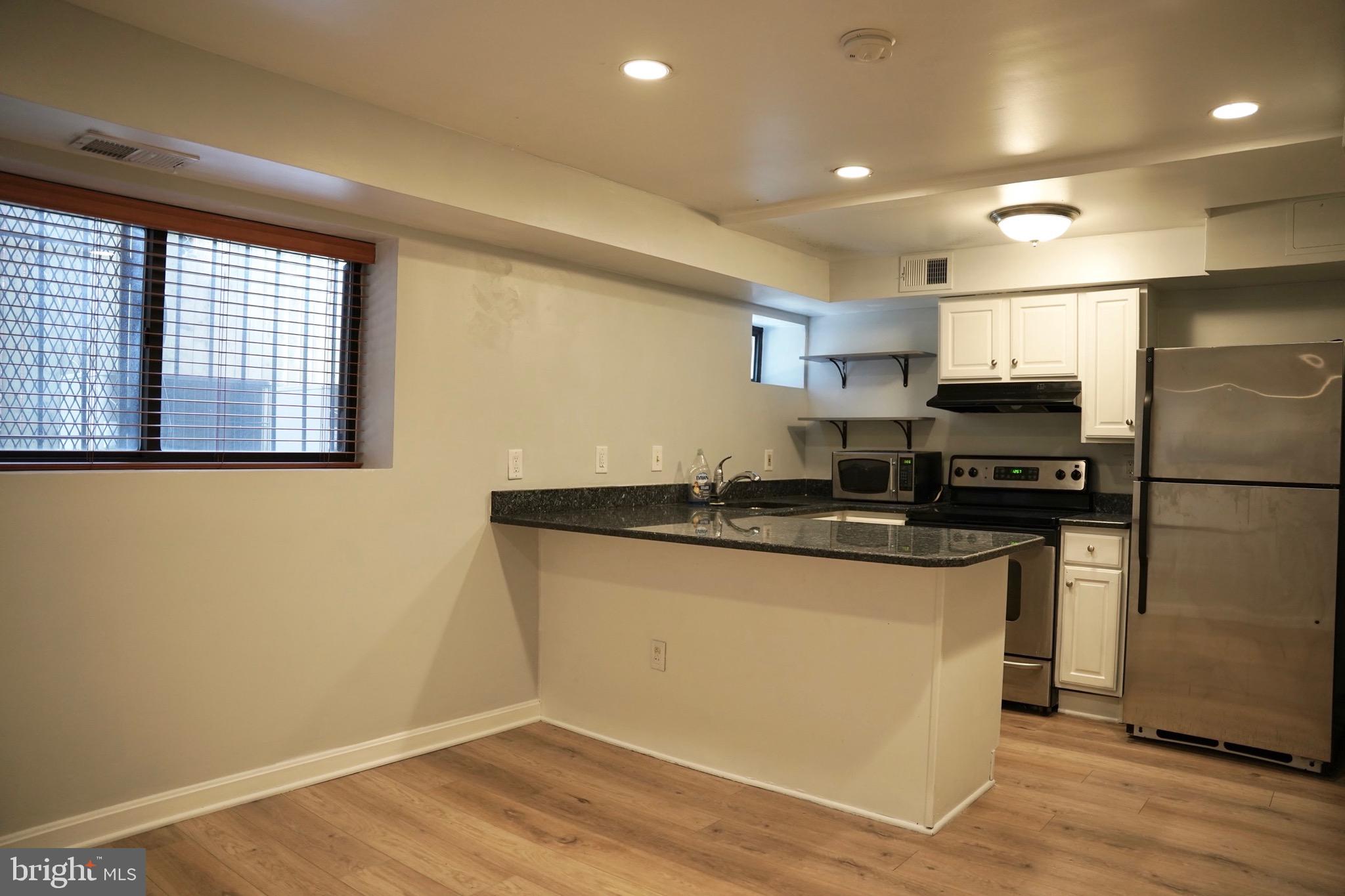 1321 Fairmont Street Northwest, Unit 3 Washington, DC 20009 - Photo 6 of 13 a kitchen with stainless steel appliances granite countertop a stove a sink and a refrigerator