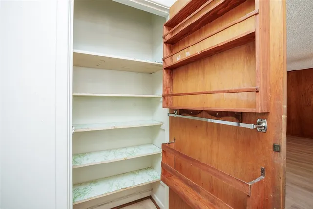 a view of walk in closet with empty racks