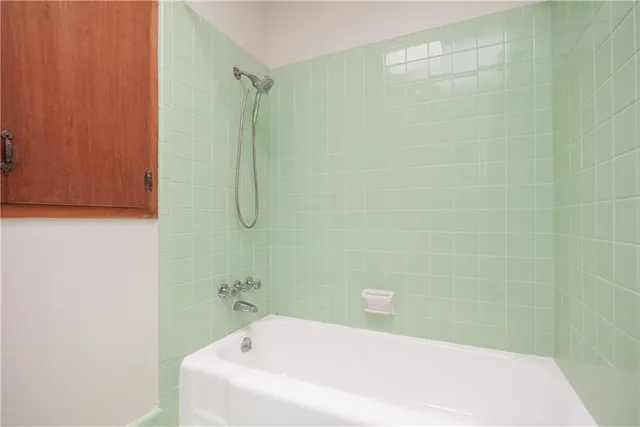 a bathroom with a white bath tub and shower