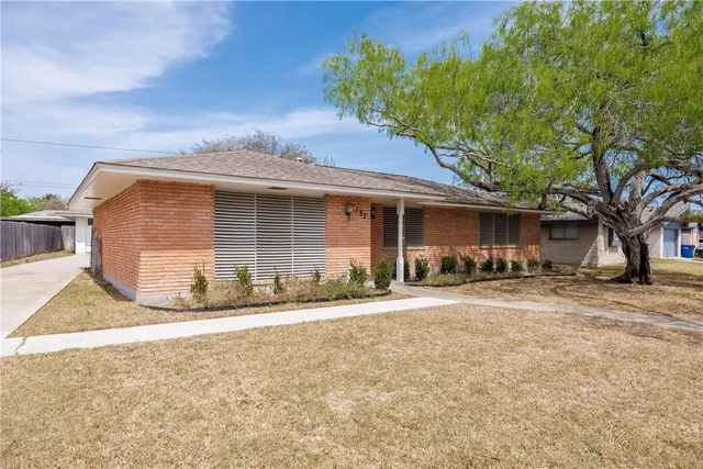 a front view of a house with a garden