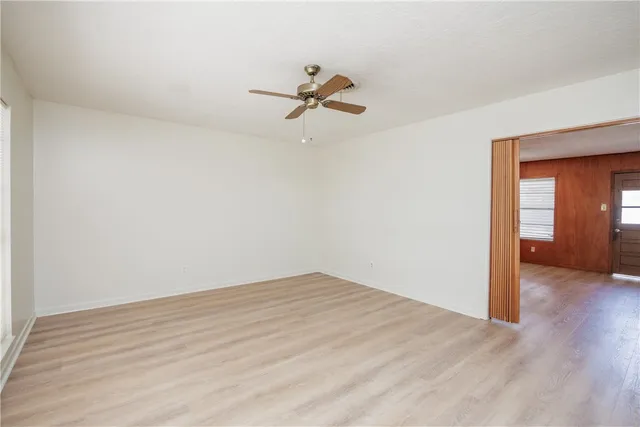 a view of a room with wooden floor and a ceiling fan