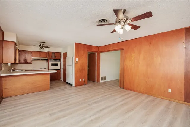 a view of kitchen with stainless steel appliances granite countertop cabinets and wooden floor