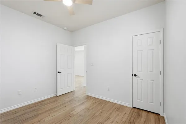 a view of an empty room with wooden floor