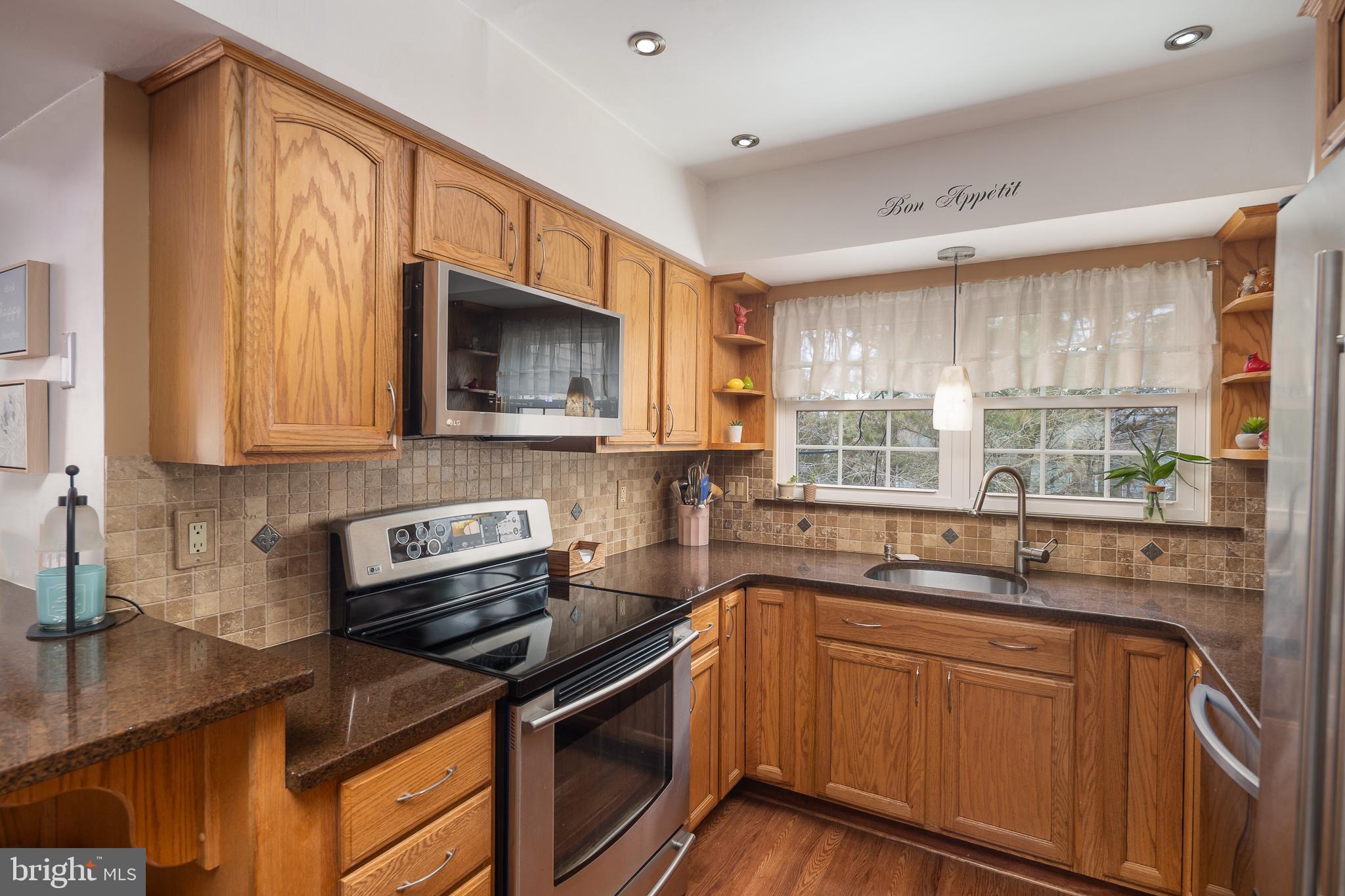 9210 Caspian Way, Unit 302 Manassas, VA 20110 - Photo 13 of 40 a kitchen with granite countertop a sink stove and microwave