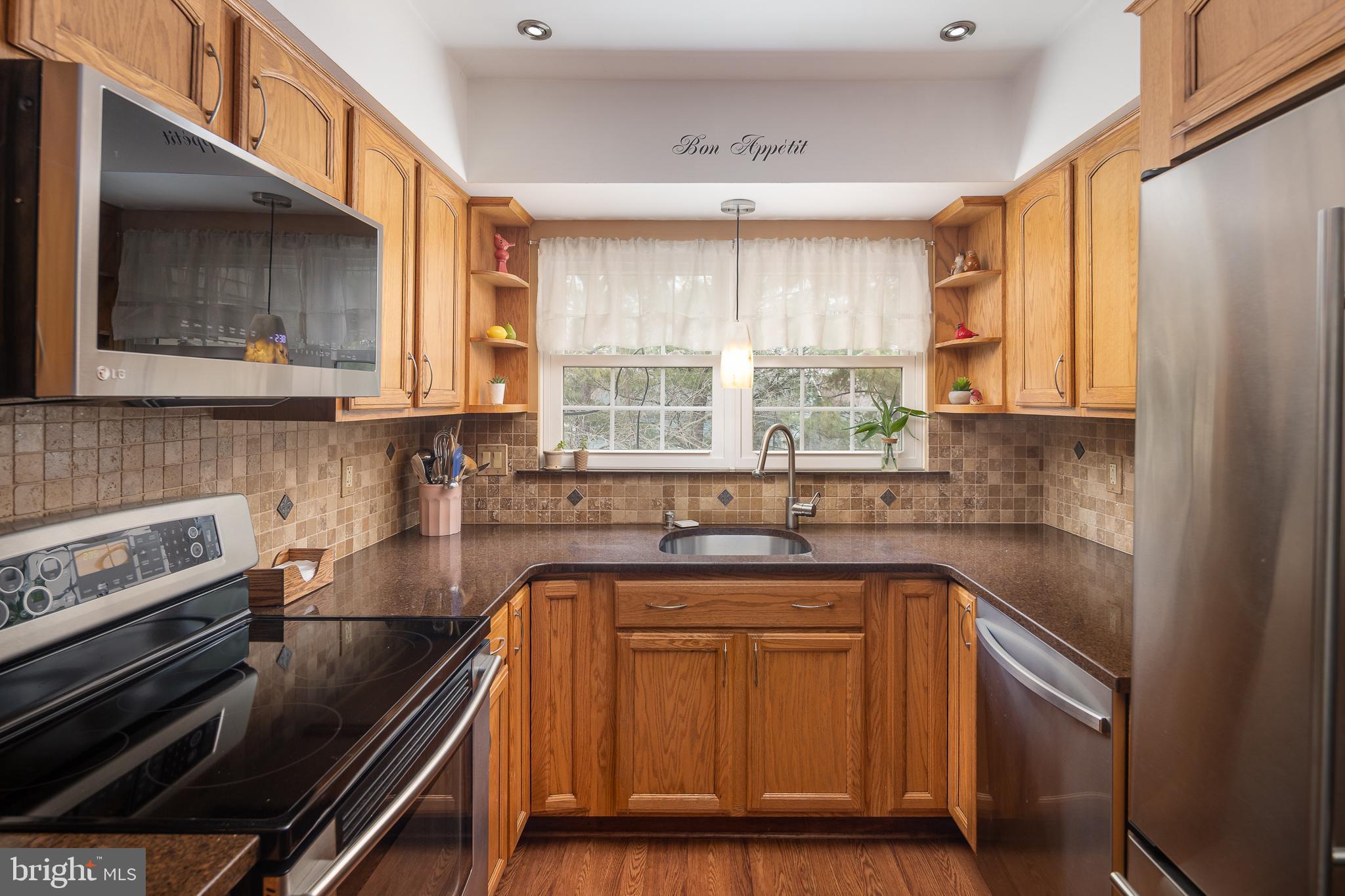 9210 Caspian Way, Unit 302 Manassas, VA 20110 - Photo 14 of 40 a kitchen with a sink stove and cabinets