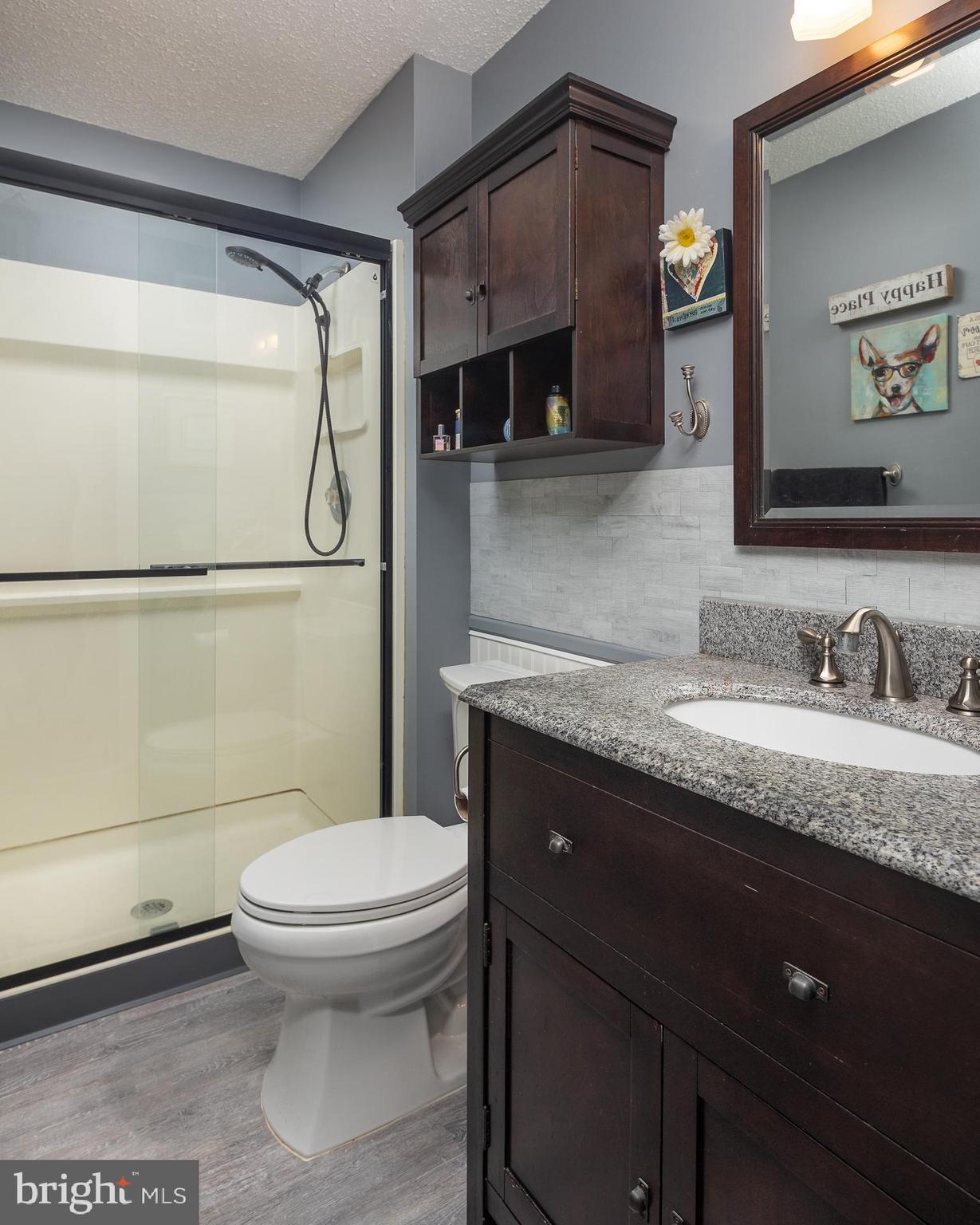 9210 Caspian Way, Unit 302 Manassas, VA 20110 - Photo 16 of 40 a bathroom with a granite countertop sink toilet and shower