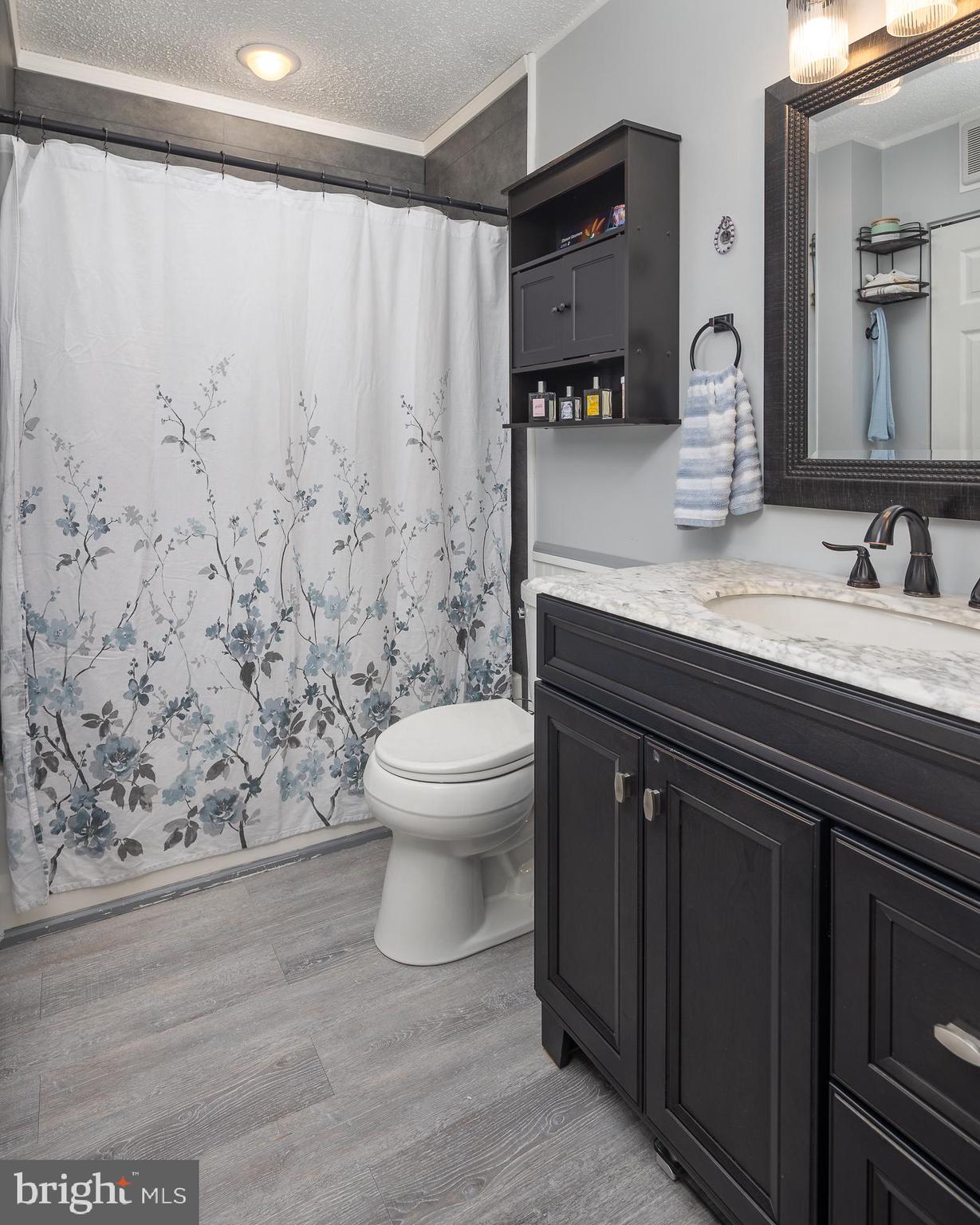 9210 Caspian Way, Unit 302 Manassas, VA 20110 - Photo 19 of 40 a bathroom with a granite countertop sink a toilet and a mirror