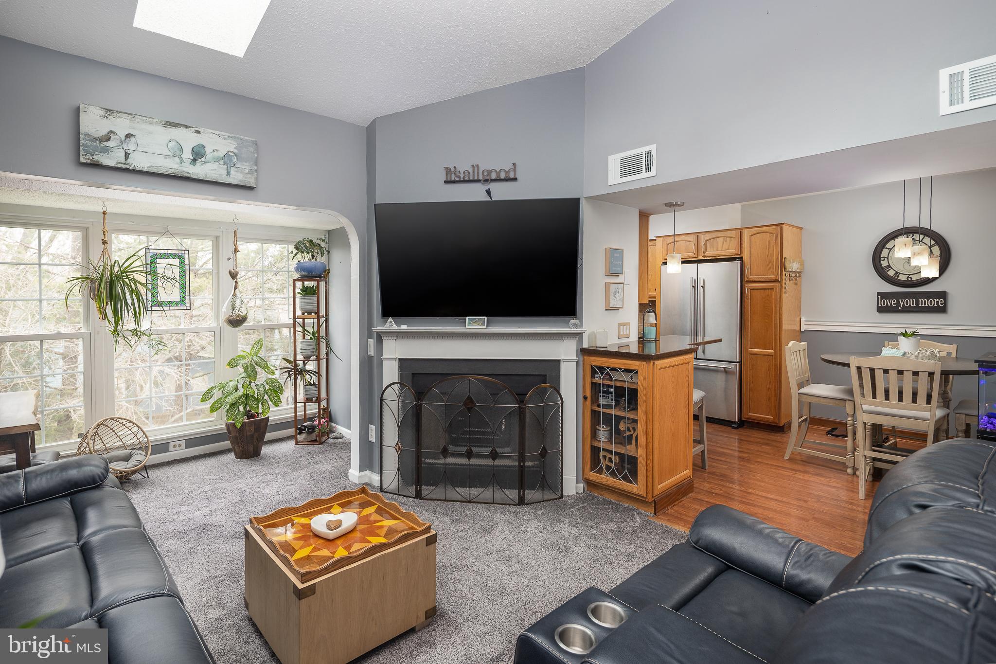 9210 Caspian Way, Unit 302 Manassas, VA 20110 - Photo 6 of 40 a living room with furniture flat screen tv and a fireplace