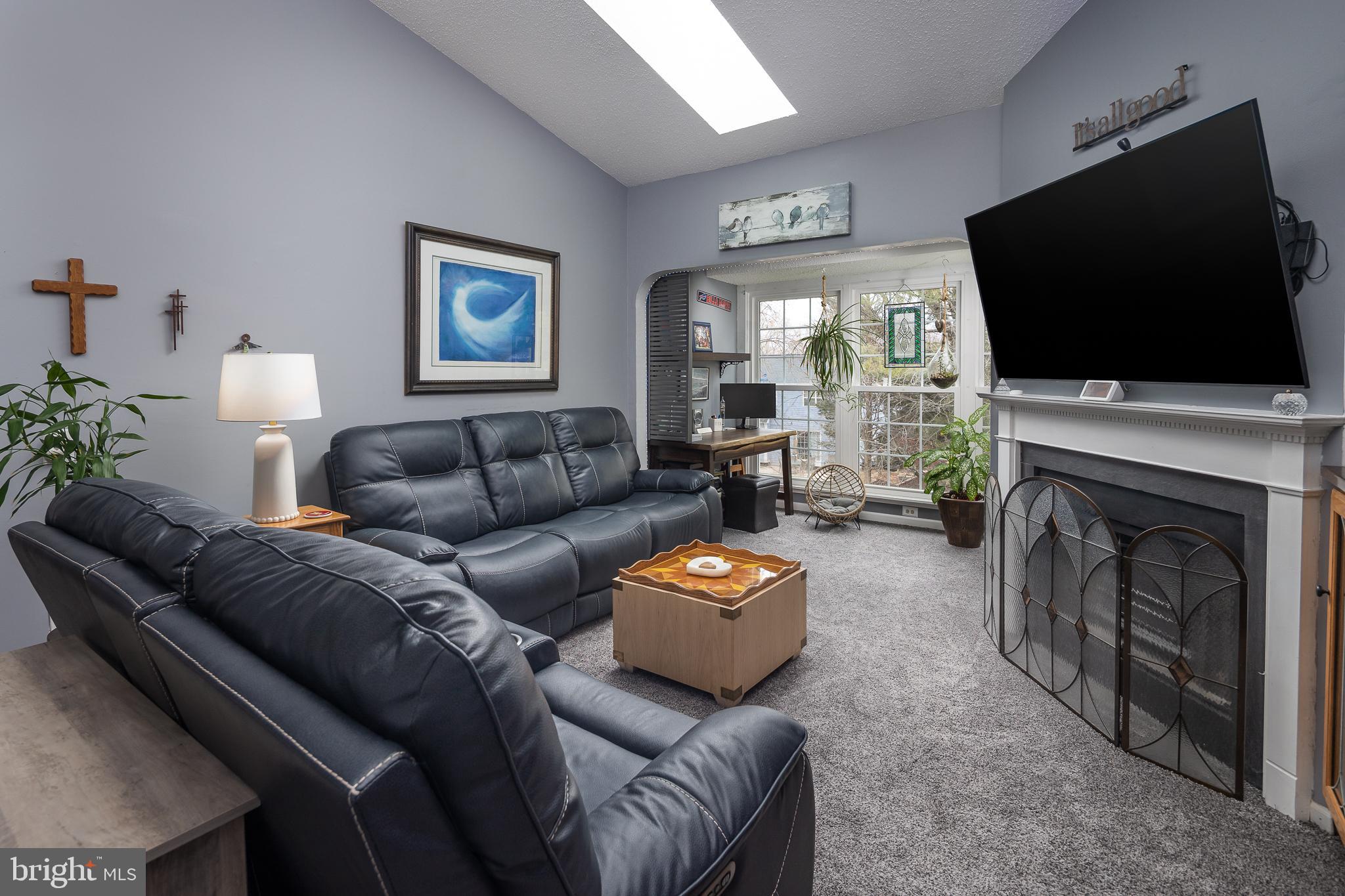9210 Caspian Way, Unit 302 Manassas, VA 20110 - Photo 8 of 40 a living room with furniture a flat screen tv and a fireplace