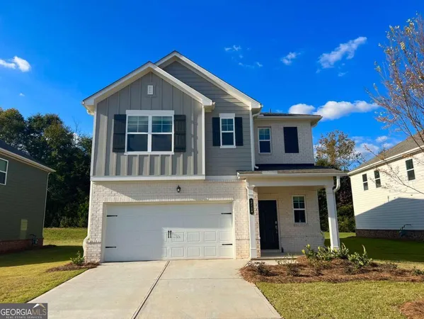 a front view of a house with yard garage and outdoor seating