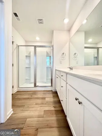a spacious bathroom with a shower sink and mirror