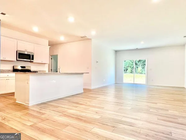 a view of a kitchen with wooden floor and a sink