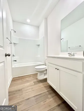 a bathroom with a sink a toilet and a large mirror