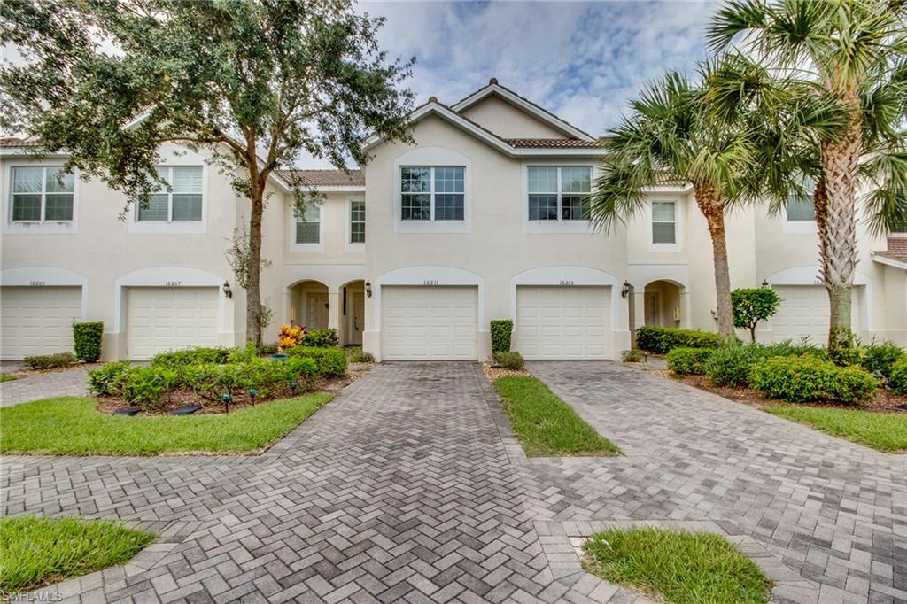 a front view of a house with a garden and trees