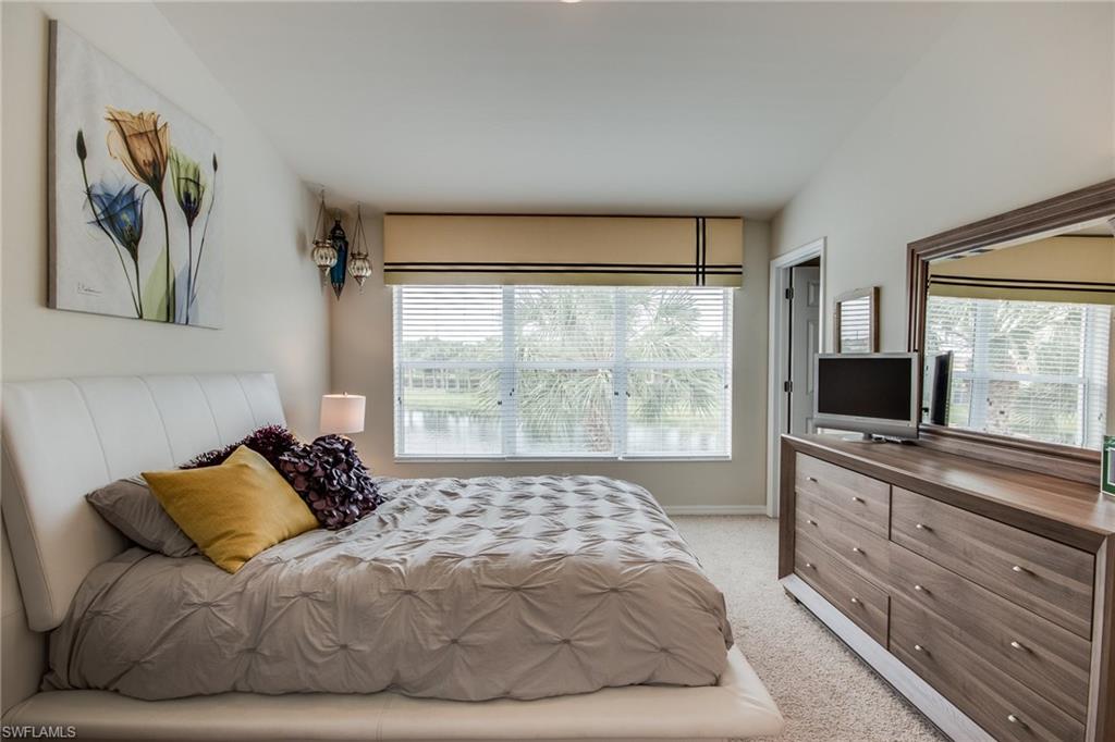 16211 Ravina Way, Unit 18 Naples, FL 34110 - Photo 13 of 25 a large bedroom with a bed and a large window