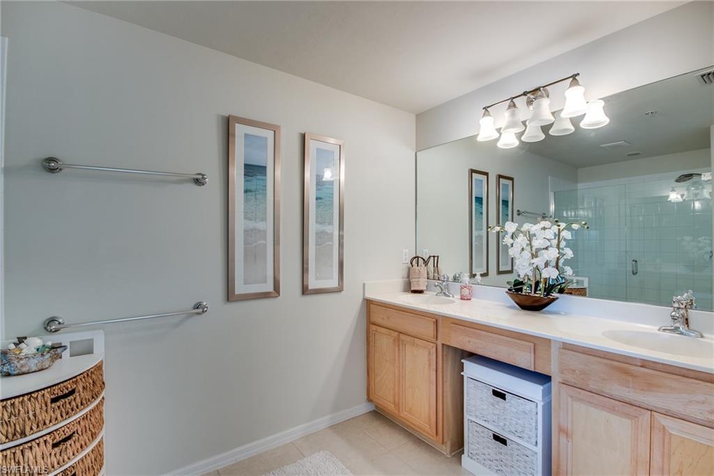 16211 Ravina Way, Unit 18 Naples, FL 34110 - Photo 15 of 25 a bathroom with a double vanity sink and a mirror