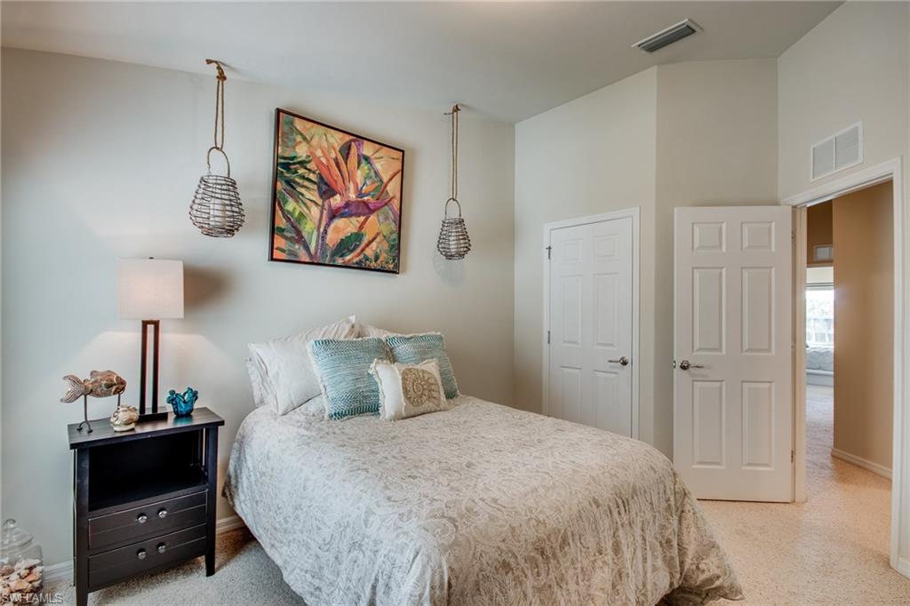 16211 Ravina Way, Unit 18 Naples, FL 34110 - Photo 18 of 25 a bedroom with a bed and a lamp on the dresser