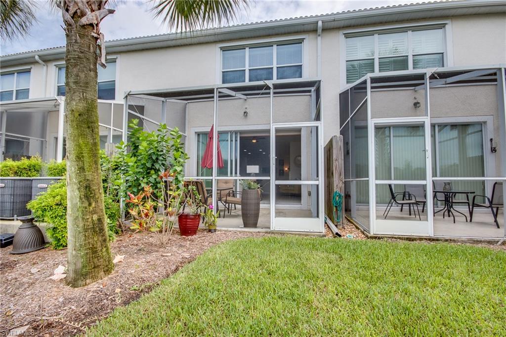 16211 Ravina Way, Unit 18 Naples, FL 34110 - Photo 24 of 25 front view of a house with a yard and potted plants