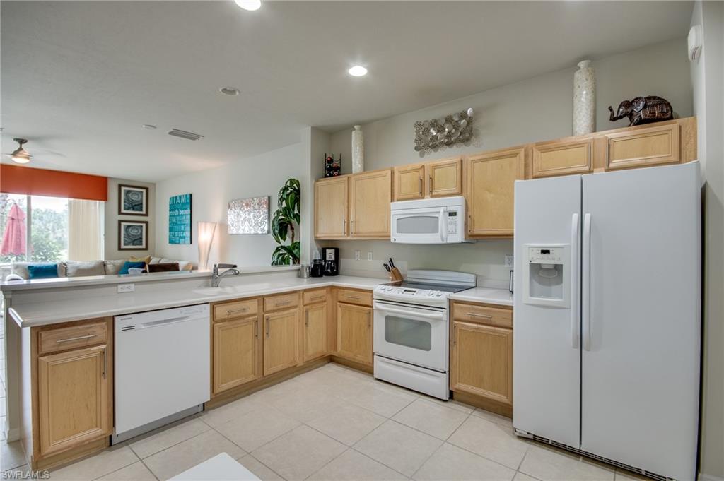 16211 Ravina Way, Unit 18 Naples, FL 34110 - Photo 5 of 25 a kitchen with white cabinets and white appliances