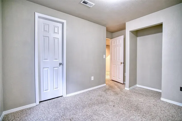 an empty room with closet and a bathroom