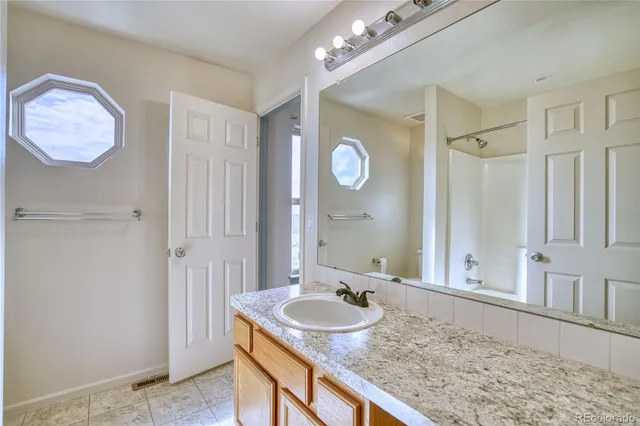 a bathroom with a granite countertop sink and a mirror