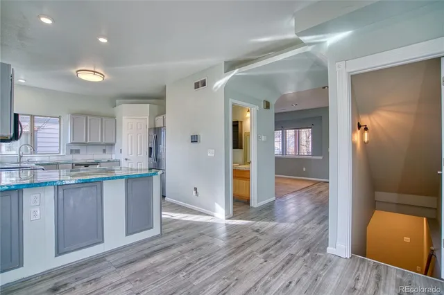 a view of a kitchen with wooden floor and a sink