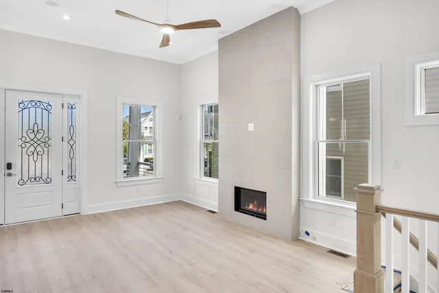 an empty room with windows and fireplace