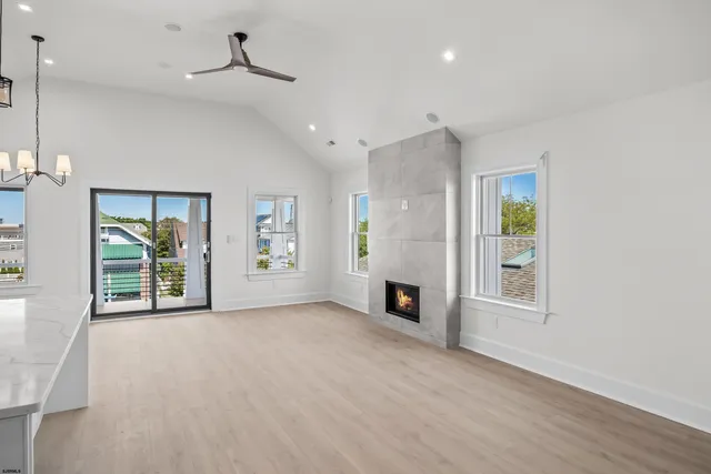 a view of an empty room with a window and fireplace