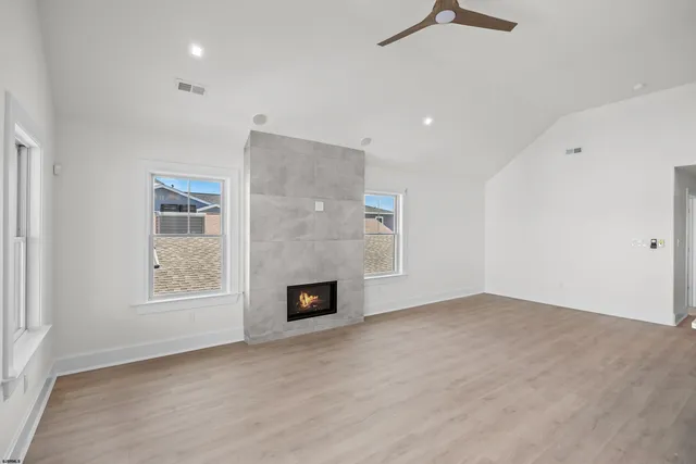 a large white kitchen with kitchen island a sink a center island stainless steel appliances and a fireplace