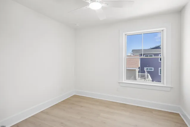 an empty room with fan and windows