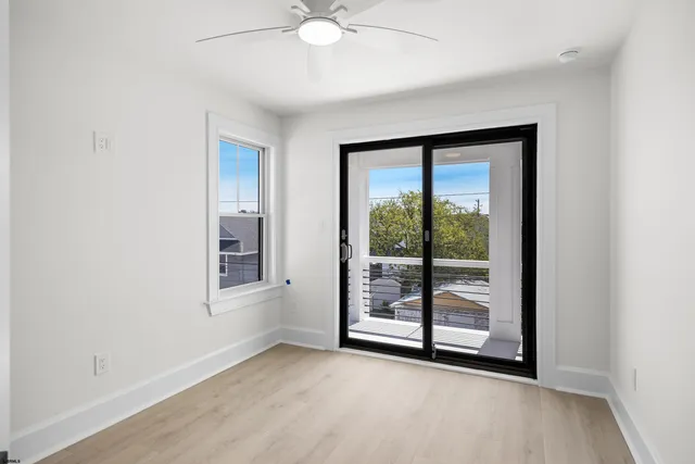 an empty room with windows and fan