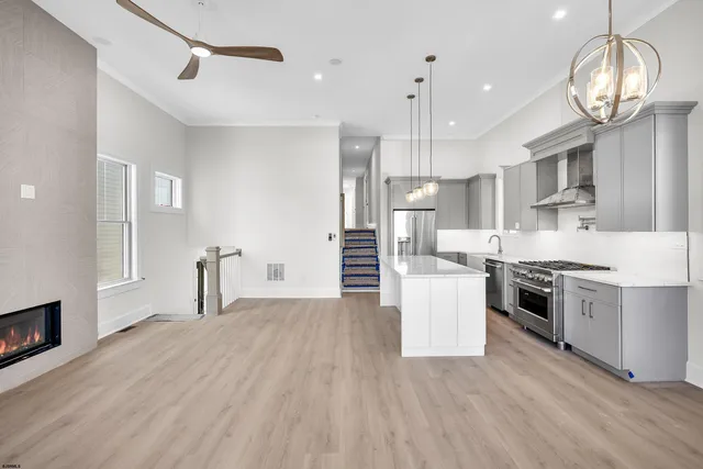 a kitchen with stainless steel appliances granite countertop a stove and a wooden floors