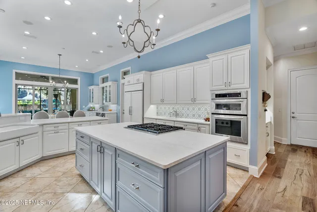 a spacious bedroom with a bed a fireplace and a chandelier