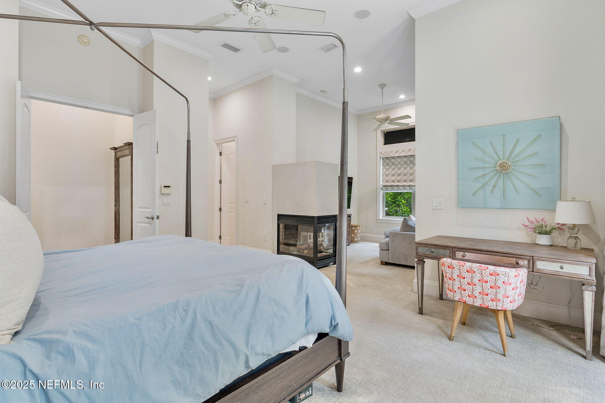 1141 Popolee Road St. Johns, FL 32259 - Photo 30 of 79 a spacious bedroom with a bed a fireplace and a chandelier