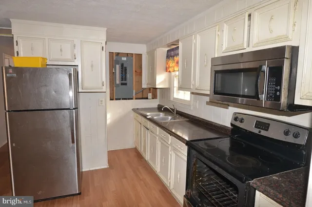 a kitchen with stainless steel appliances granite countertop a stove a refrigerator and a microwave