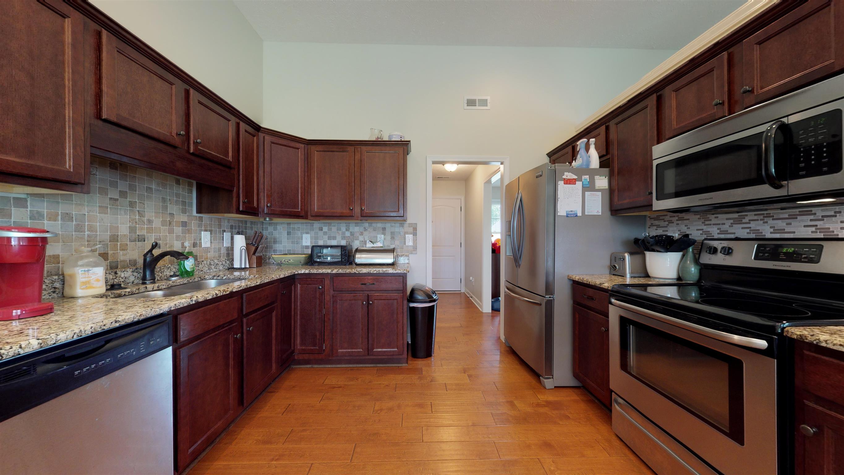 108 Riddick Court Murfreesboro, TN 37127 - Photo 4 of 14 Kitchen offers SS appliances, tile backslash, wood floors and granite