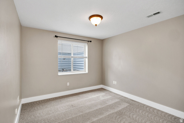 2912 South 1080th Street West Logan, UT 84321 - Photo 24 of 43 Carpeted room featuring a double-hung window with blinds, a ceiling-mounted light fixture, light gray wall paint, and white baseboards