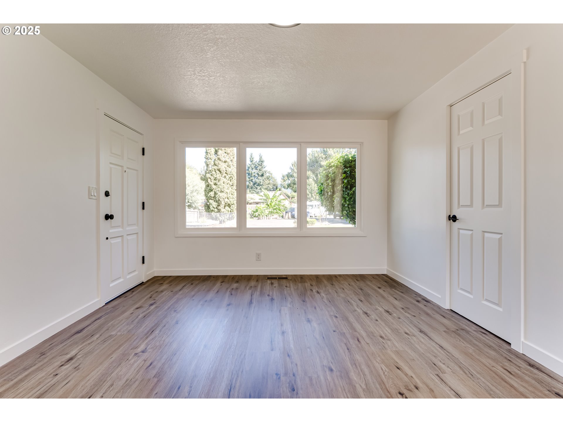 663 Swan Court Springfield, OR 97477 - Photo 30 of 31 a view of an empty room with wooden floor and a window
