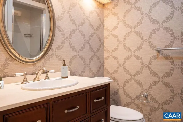 a bathroom with a granite countertop toilet sink and mirror